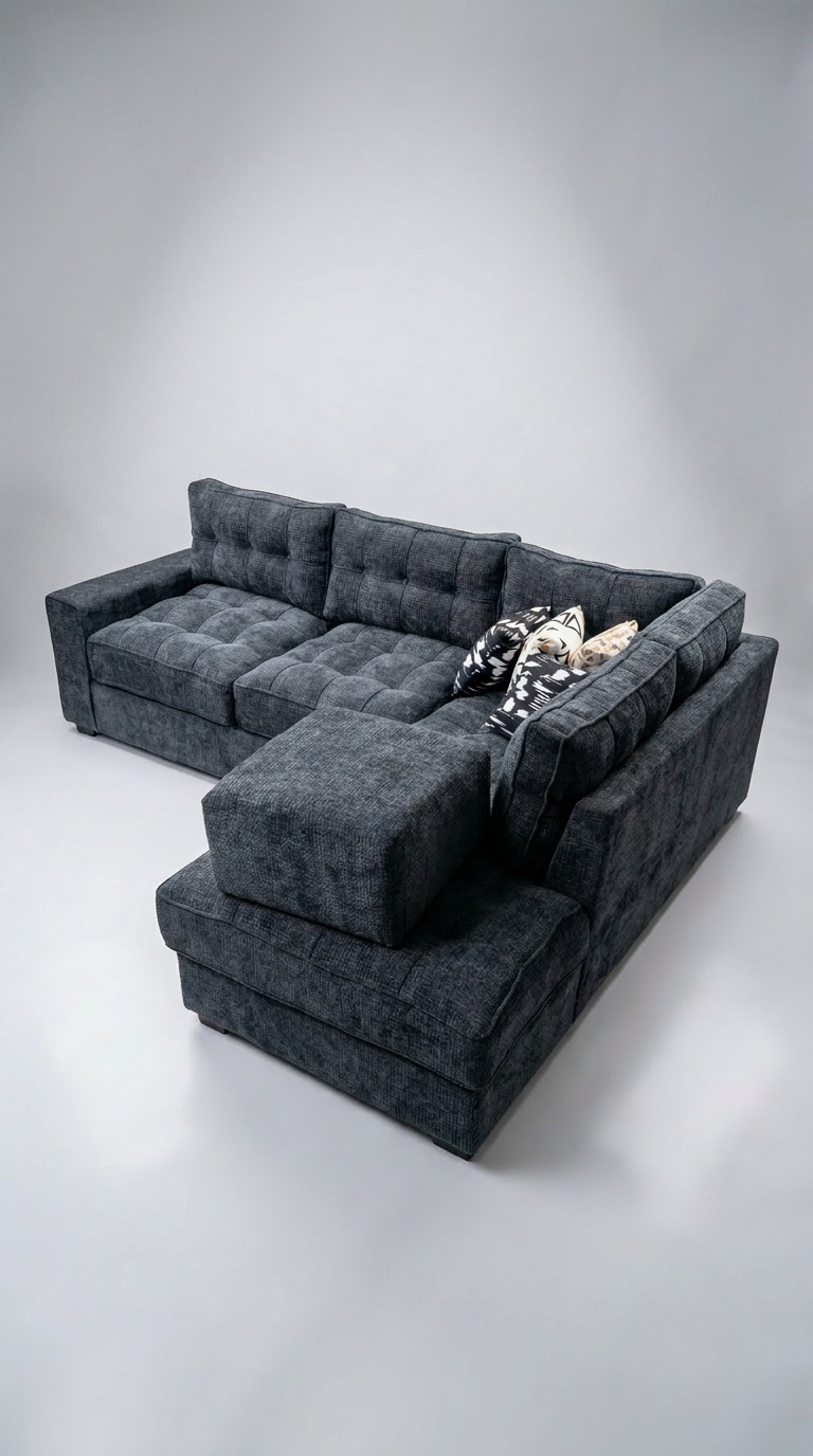 Charcoal grey tufted L-sectional with abstract pillows